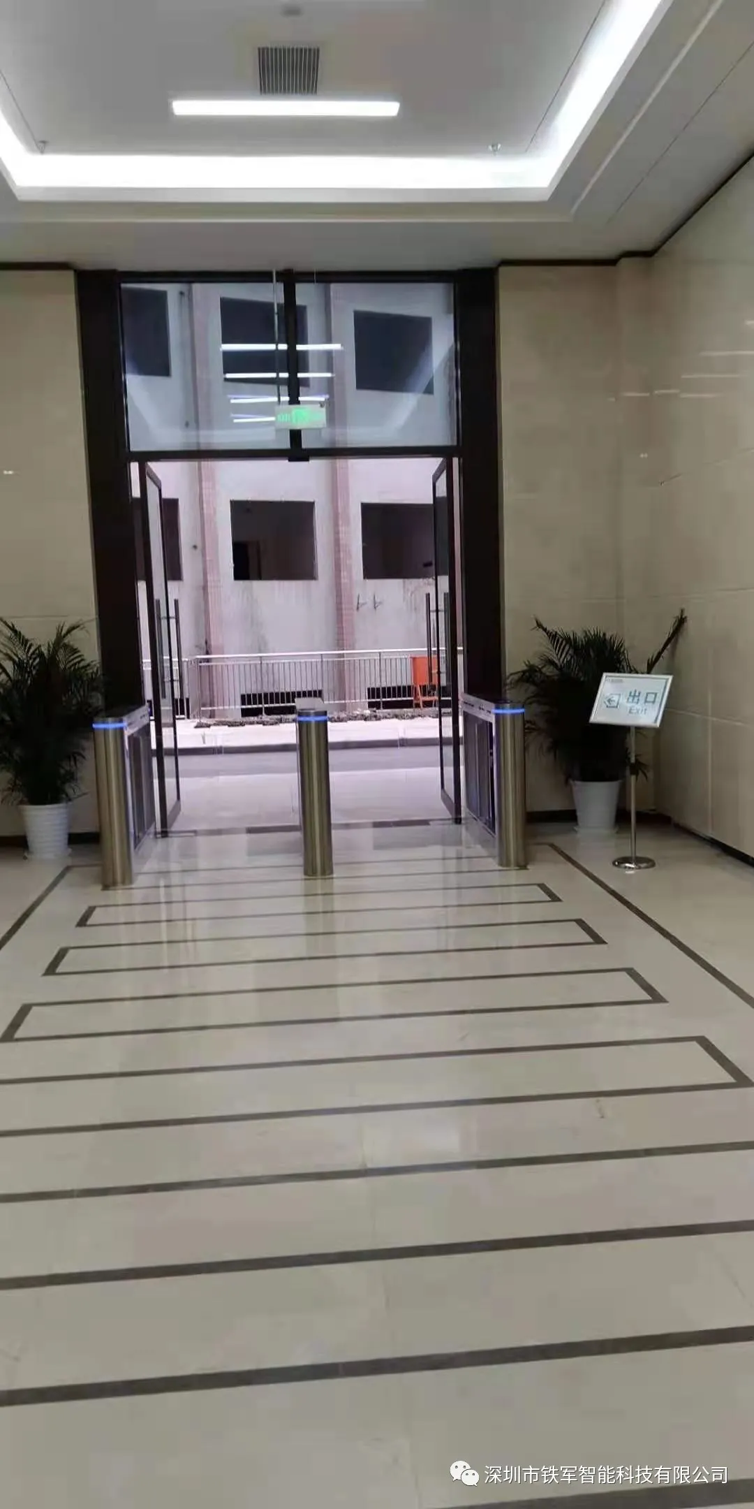 工作人員用“鐵軍智能”的豪華擺閘加健康碼測溫人臉識別一體機(jī)